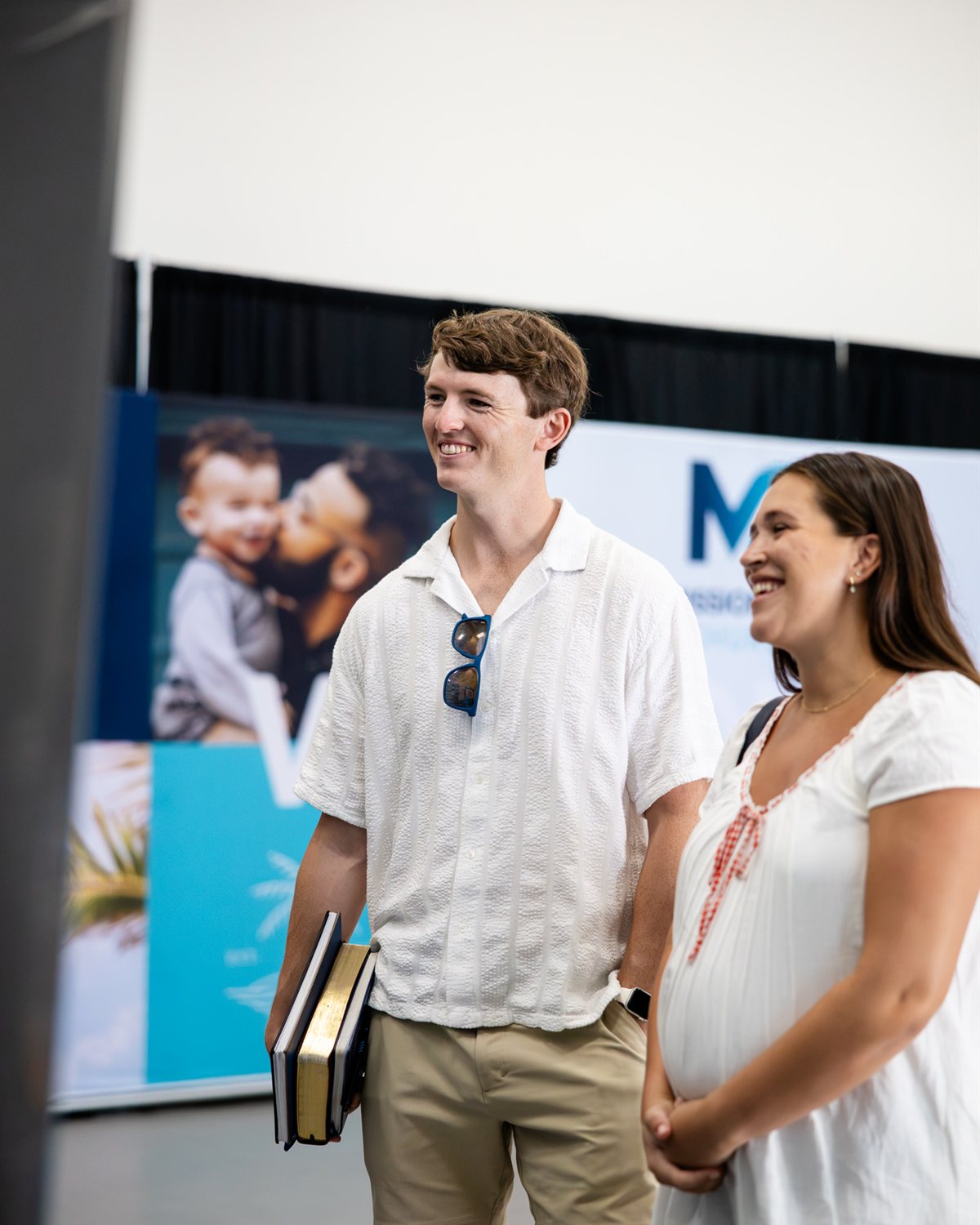 A smiling couple at the Mission City welcome wall on a Sunday morning