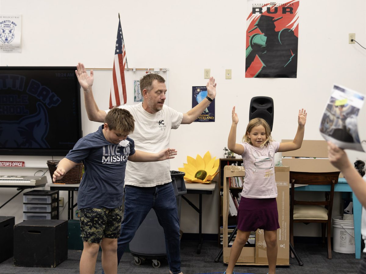 A leader and two kids doing an action game at Mission 45